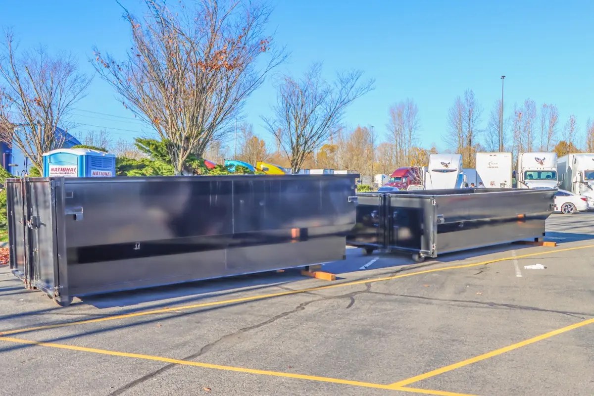 Professional dumpster rental service with roll-off container on residential driveway in St. Johns